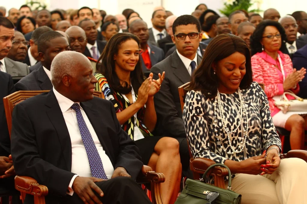 Isabe dos os Santos, applauding, sits behind her father, the late José Eduardo dos Santos, president of Angola, and his wife Ana Paula dos Santos in 2012